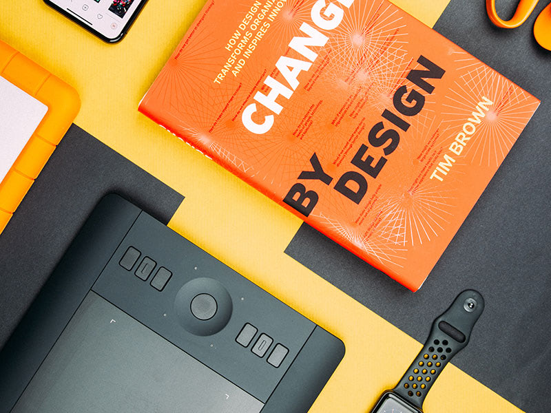 Design workspace flat lay with orange book